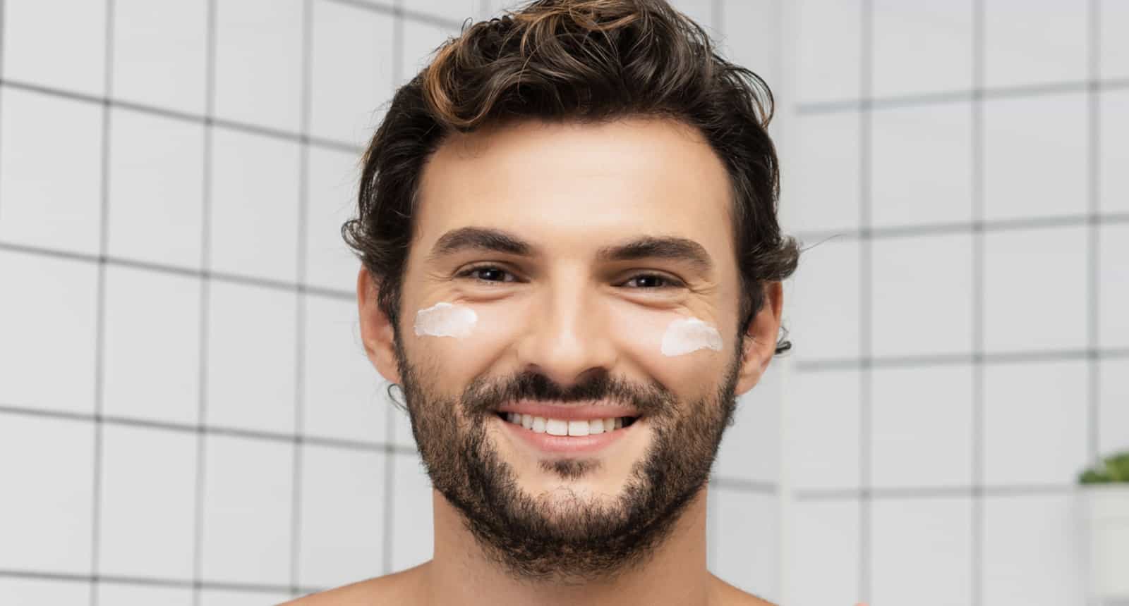 Mann mit normaler Haut lächelt in den Spiegel